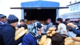 People hold bread loaves provided by rescuers after an earthquake in the Ercis province of Van, in eastern Turkey, October 24, 2011. (AFP)